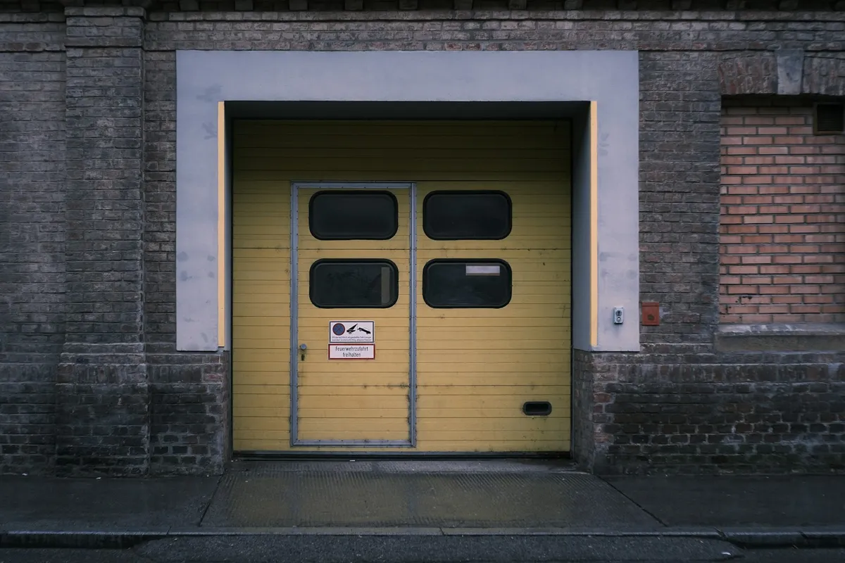 Yellow sectional door with windows set in a brick wall